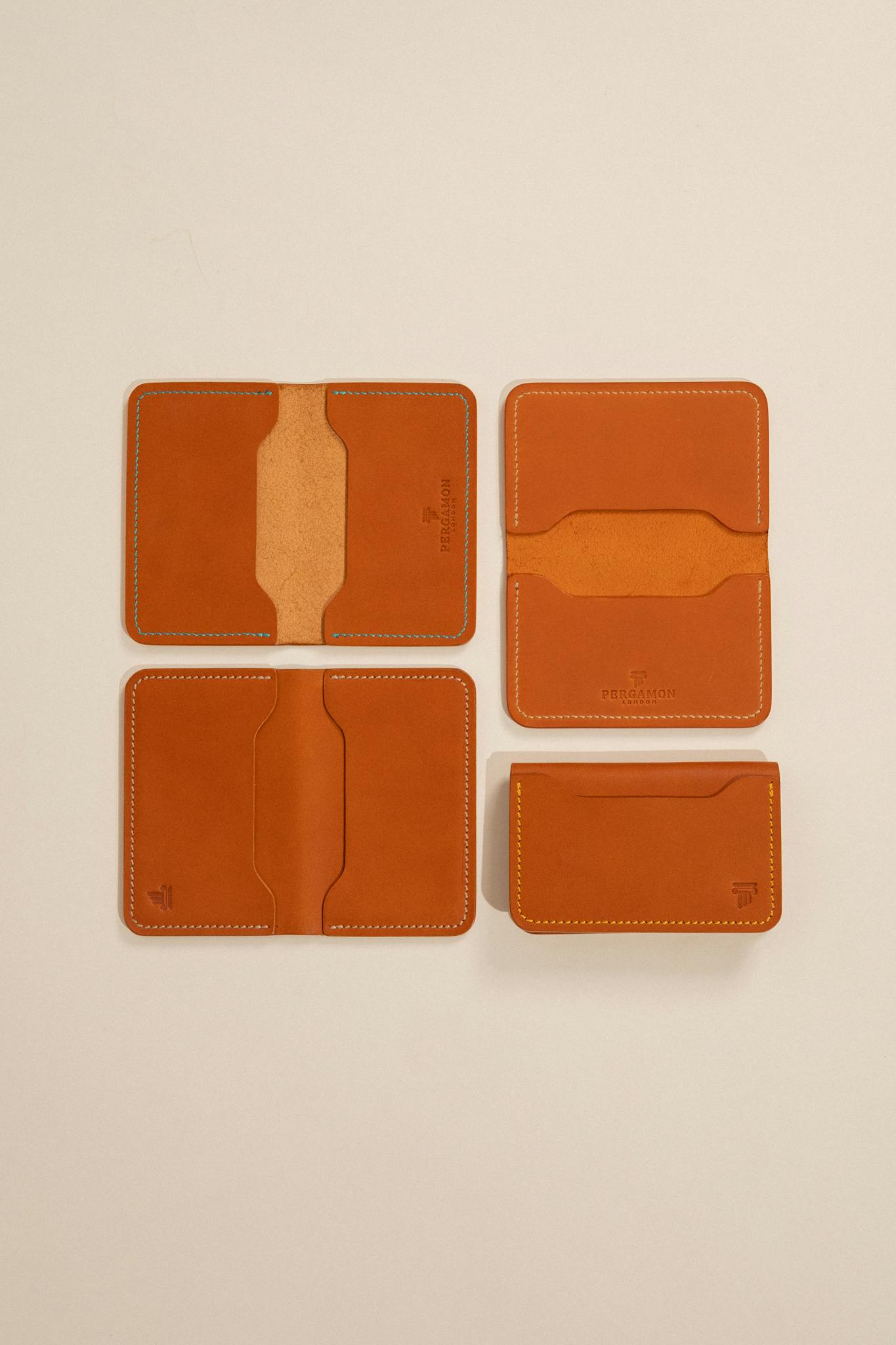Stylish minimalist leather wallets displayed against a beige backdrop, showcasing craftsmanship and design.